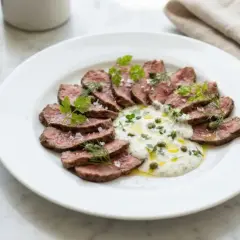 Skivad biff med krämig sås, kapris och örter. Ett perfekt café de Paris sås recept för en lyxig måltid.