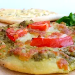 En läcker manakish ost med pesto och tomater, redo att avnjutas.