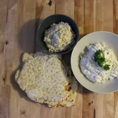 Två skålar med krämig tarator djej, en med persilja, bredvid tunna, krispiga bröd.