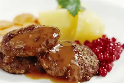 Stekta köttbullar med en härlig brunsås utan grädde, serverade med potatis och lingon.