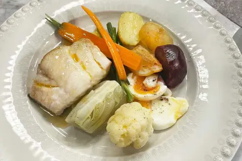 En vacker tallrik med fisk, kokt ägg, potatis, morötter, blomkål och rödbetor. En härlig grand aioli-upplevelse!