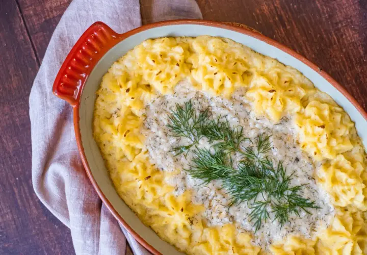 En krämig vegetarisk fisksås med potatismos och dill i en ugnsform.