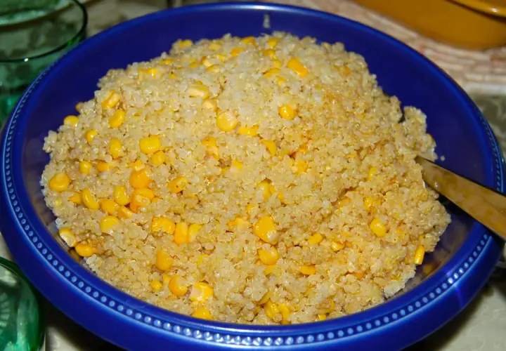 En blå skål fylld med fluffig quinoa och söta majskorn. Perfekt för att koka quinoa till en hälsosam måltid.