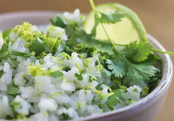 En skål med fluffigt mexikanskt ris, toppat med färsk koriander och limezest. Perfekt som tillbehör till din favorit tacorätt.