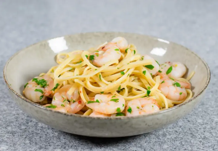 En skål med linguine och scampi, perfekt för ett snabbt scampi recept. Garnerad med färsk persilja.