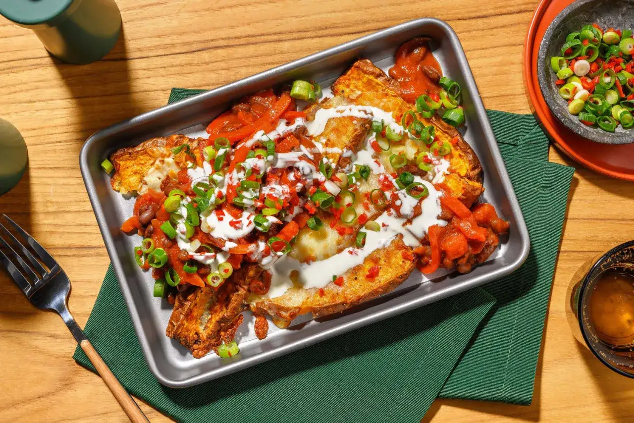 Ugnsbakade potatishalvor med chili, bönor och en generös klick gräddfil. En smakrik rätt där gräddfil kcal bidrar till krämigheten.