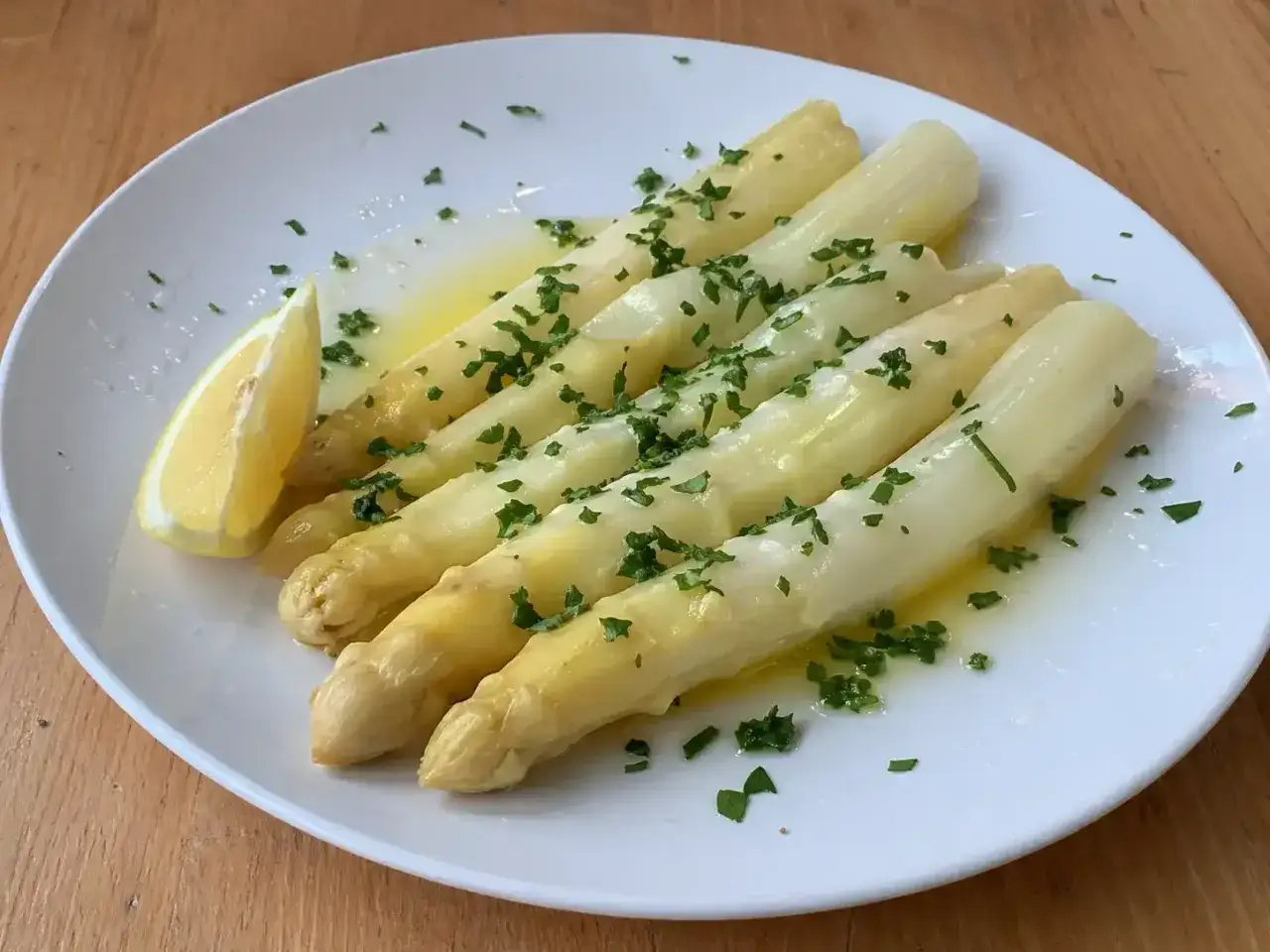 Vitt sparris, perfekt tillagat och serverat med smält smör, färsk persilja och en citronklyfta. En enkel men utsökt rätt att koka sparris till.