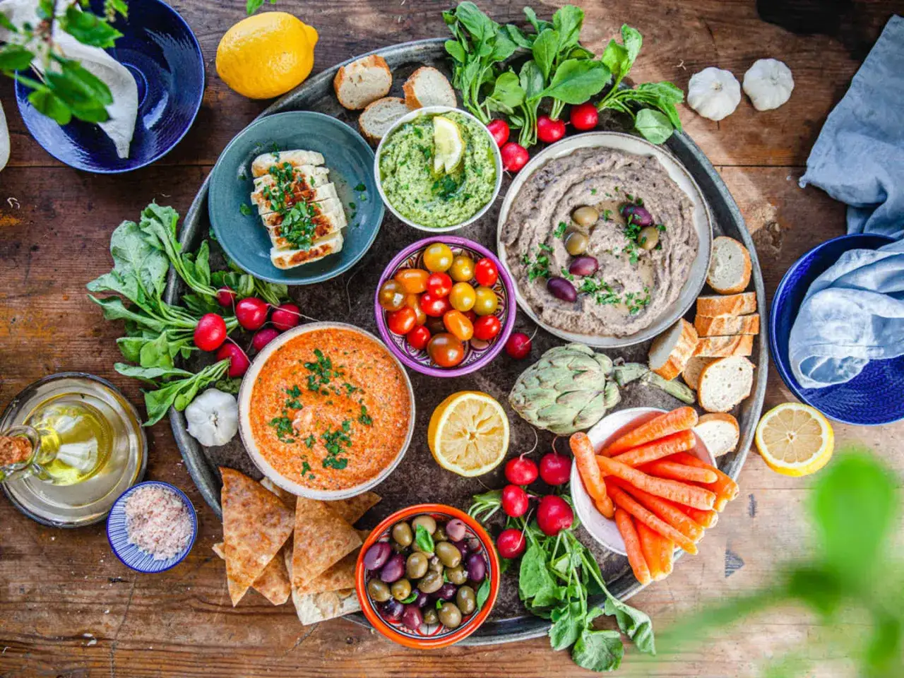 En härlig buffé med grekisk mat: hummus, baba ghanoush, grillad halloumi, oliver, tomater, morötter och pitabröd.