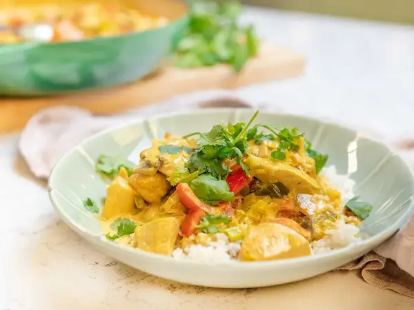 En krämig kyckling curry med ris, toppad med färsk koriander. En härlig och smakrik rätt som passar perfekt för en mysig middag.