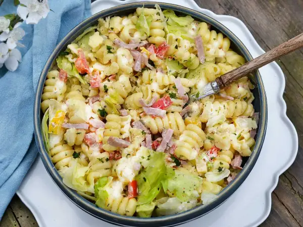 En stor skål med krämig pastasallad med skinka, tomat och sallad. Perfekt dressing till pastasallad för en sommarlunch.