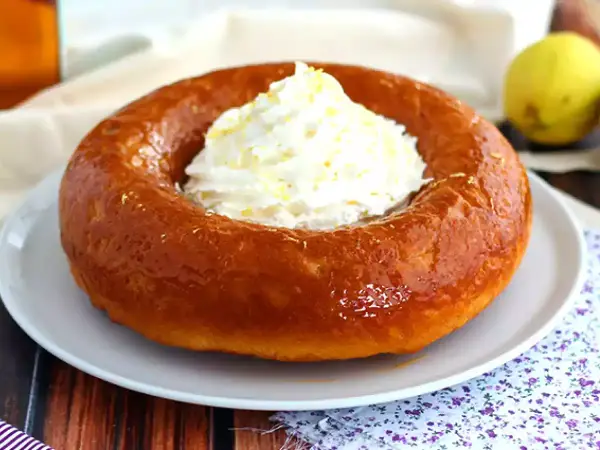 En gyllene baba, en klassisk dessert, toppas med fluffig grädde och citronskal. Perfekt för en fika!